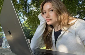 Elmira working on a laptop outdoors